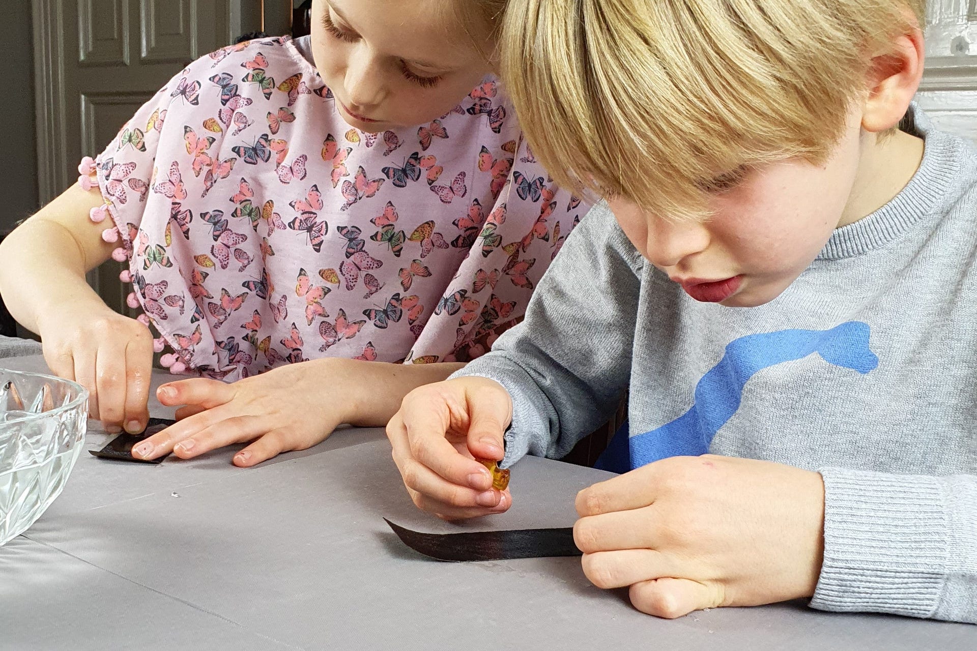 Kinder mit Bernsteinen und Schleifpapieren